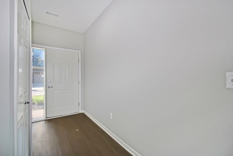 A white interior room with a door and a window.