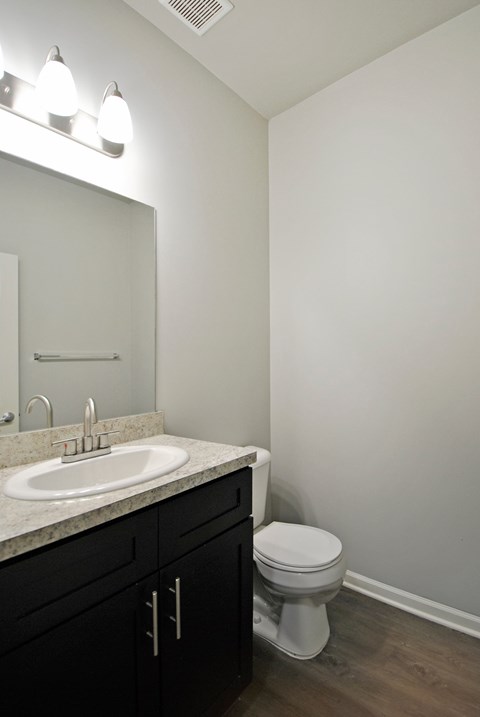 A white toilet sits next to a sink in a bathroom.