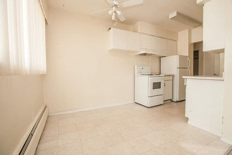 A kitchen with a white oven and a ceiling fan.