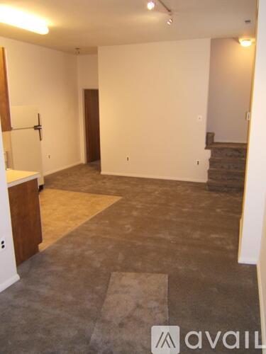 A room with a carpeted floor and a wooden cabinet.