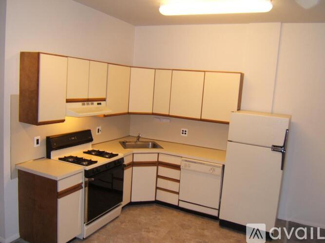 A kitchen with white appliances and brown cabinets.