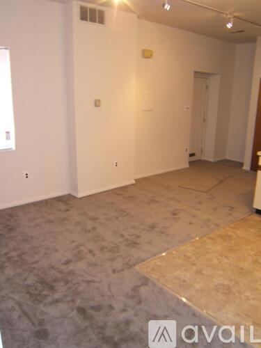 A room with a carpeted floor and a door on the right side.