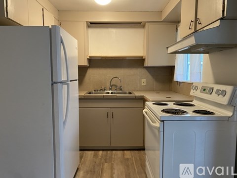 A kitchen with a white refrigerator and stove.