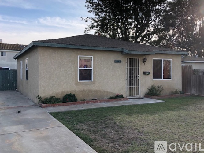 A house with a brown stucco exterior and a green roof is for sale.