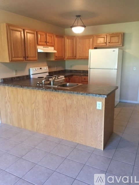 A kitchen with wooden cabinets and a white fridge.