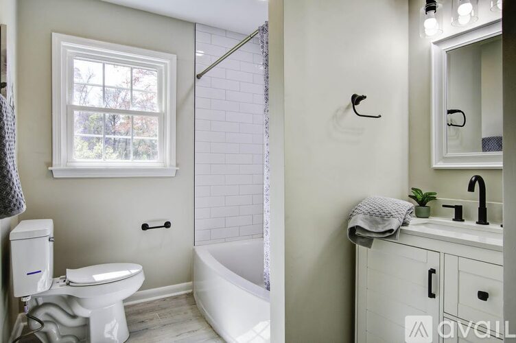 A white bathroom with a toilet, sink, and tub.