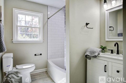 A white bathroom with a toilet, sink, and tub.