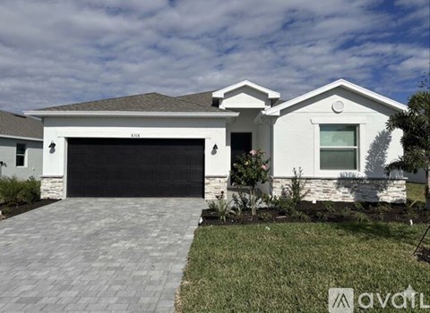 A white house with a black garage door is for sale.