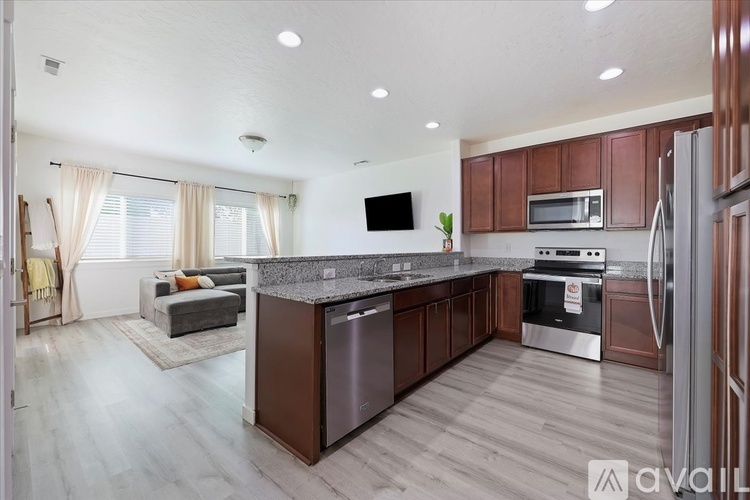 A modern kitchen with dark wood cabinets and stainless steel appliances.