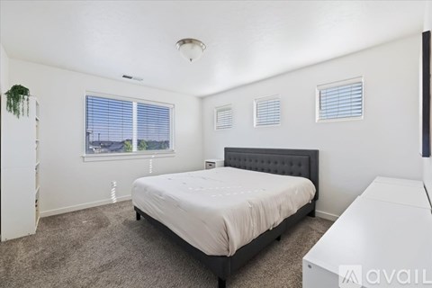 A bedroom with a bed, window, and a potted plant.