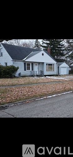 A house with a white front yard and a grey roof.