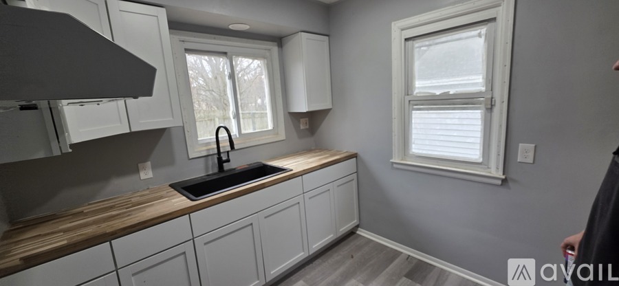A kitchen with white cabinets and a window.
