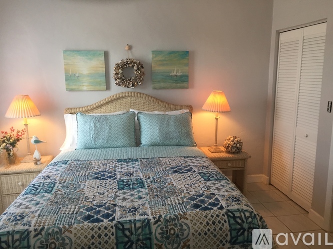A bedroom with a bed covered in a blue and white patterned comforter.