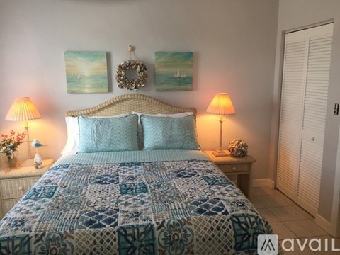 A bedroom with a bed covered in a blue and white patterned comforter.