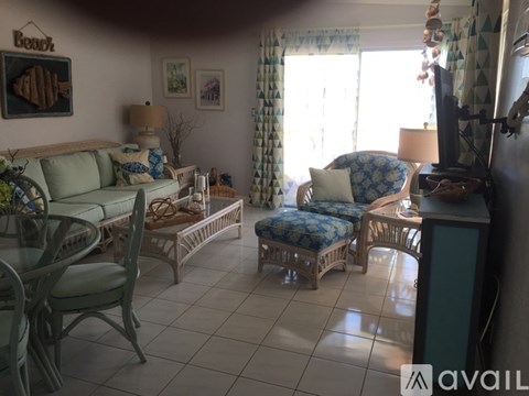 A living room with a sofa, chairs, and a television.