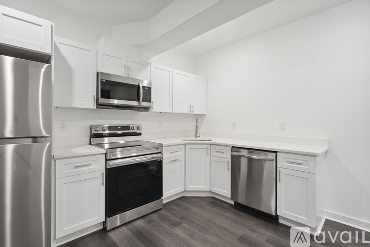 A modern kitchen with white cabinets and stainless steel appliances.