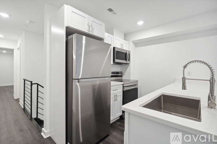 A modern kitchen with a stainless steel refrigerator, microwave, and oven.