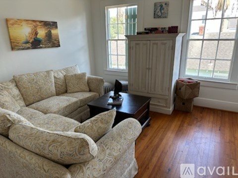 A living room with a couch, coffee table, and a painting on the wall.
