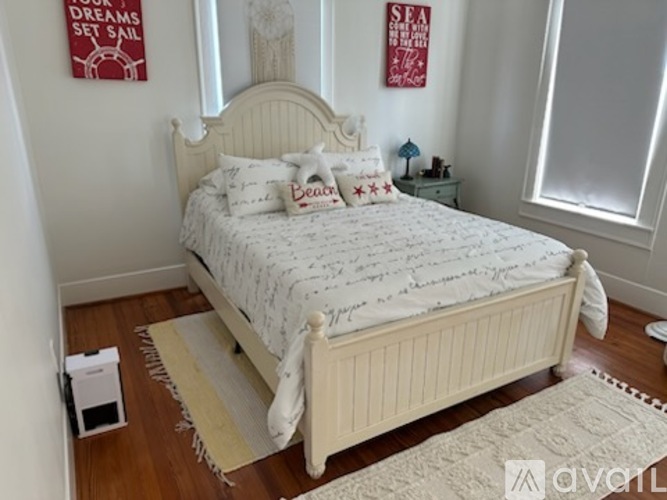 A bedroom with a bed, a nightstand, and two posters on the wall.