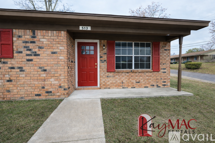 A brick house with a red door and a sign that says 513.