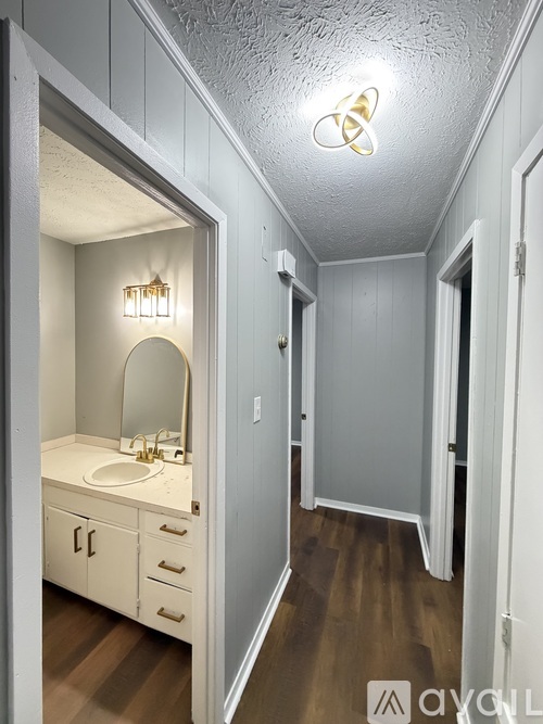 A bathroom with a sink, mirror, and light fixture.