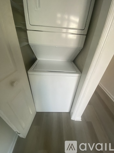 A white fridge in a narrow hallway.