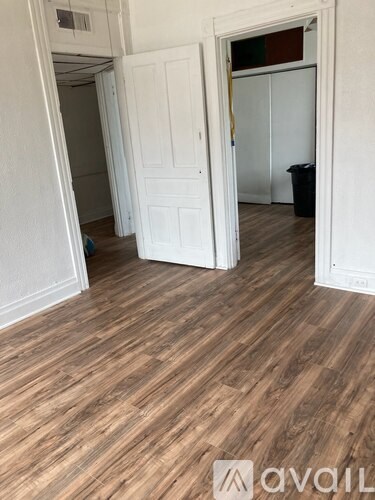A room with wooden floors and two white doors.