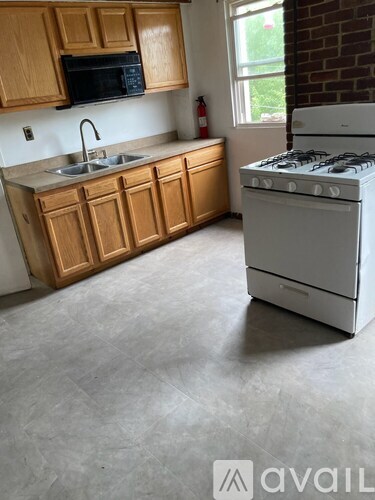 A kitchen with wooden cabinets and a white stove.