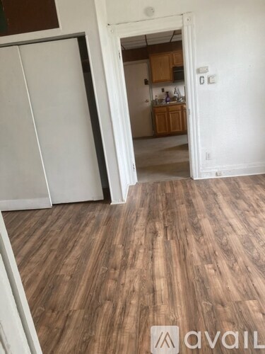 A room with wooden flooring and a white door.