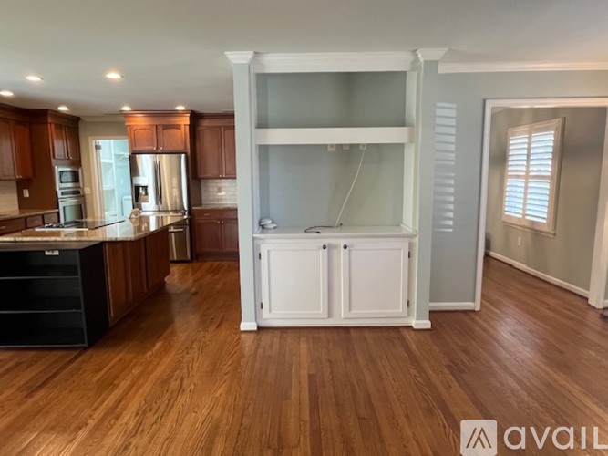 A kitchen with wooden cabinets and a black drawer unit.