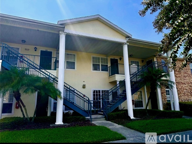 A two-story house with a front porch and stairs leading to the second floor.