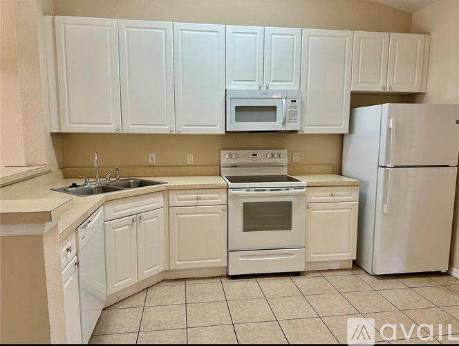 A kitchen with white cabinets and appliances.