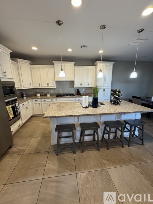 A kitchen with a large island and bar stools.