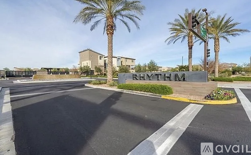 A street view with palm trees and a sign that reads "RHYTHM".