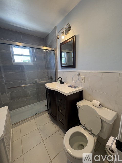 A bathroom with a toilet, sink, and shower.