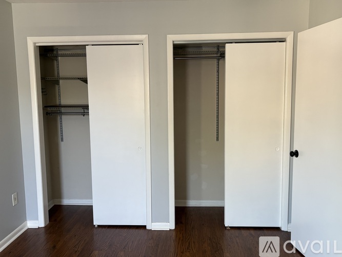 Two white closet doors in a room.