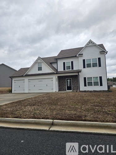 A two-story house with a garage is available for sale.