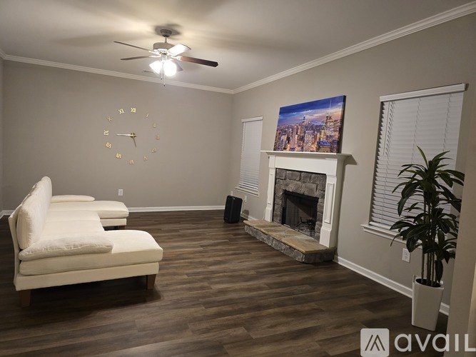 A living room with a fireplace and a painting on the wall.