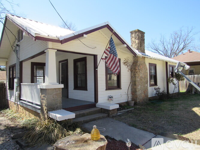 A small house with a flag on the front porch.