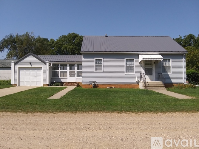 A two-story house with a garage and a covered porch.