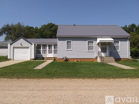 A two-story house with a garage and a covered porch.