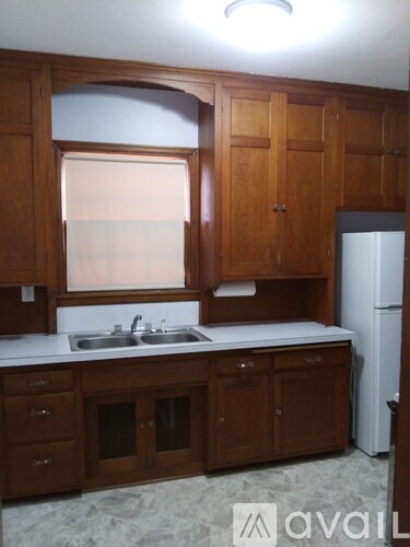 A kitchen with wooden cabinets and a white fridge.