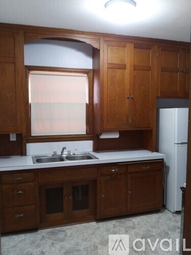 A kitchen with wooden cabinets and a white fridge.