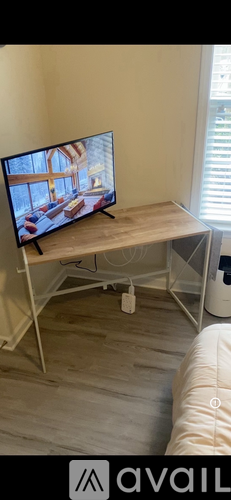 A flat screen TV is on a stand in a room.
