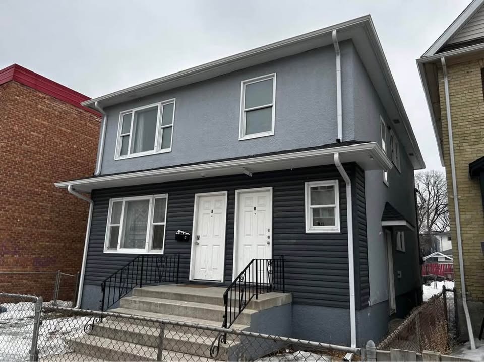 A grey house with a white door and windows.