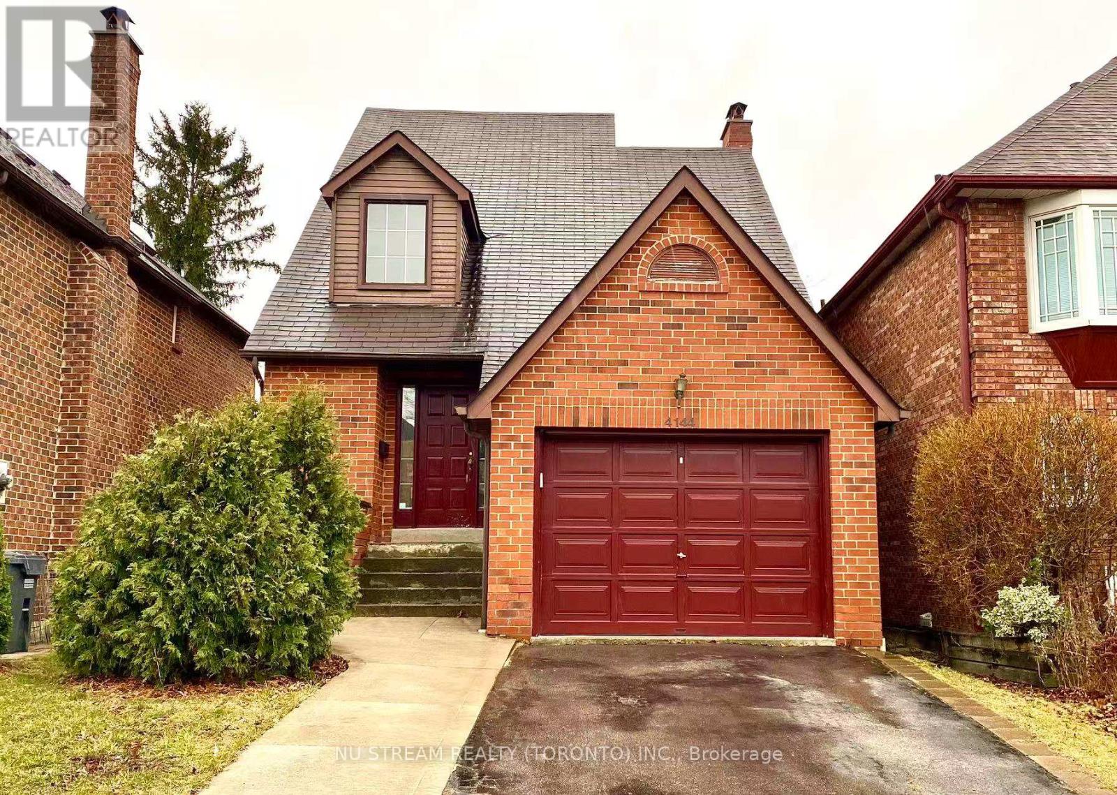 A red brick house with a garage door in the front.