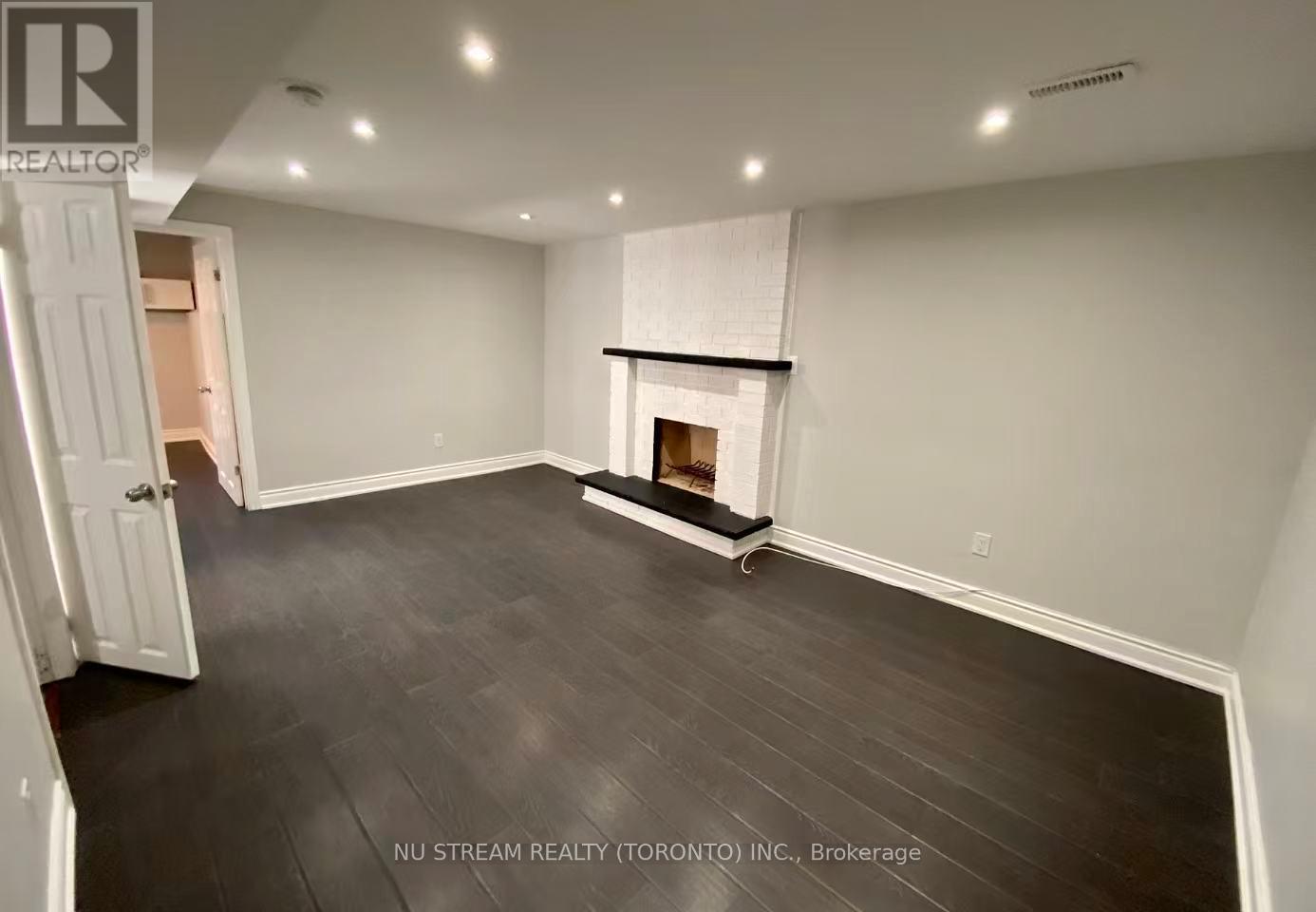 A room with a fireplace and wood flooring.