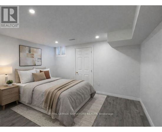A bedroom with a large bed and a wooden nightstand.