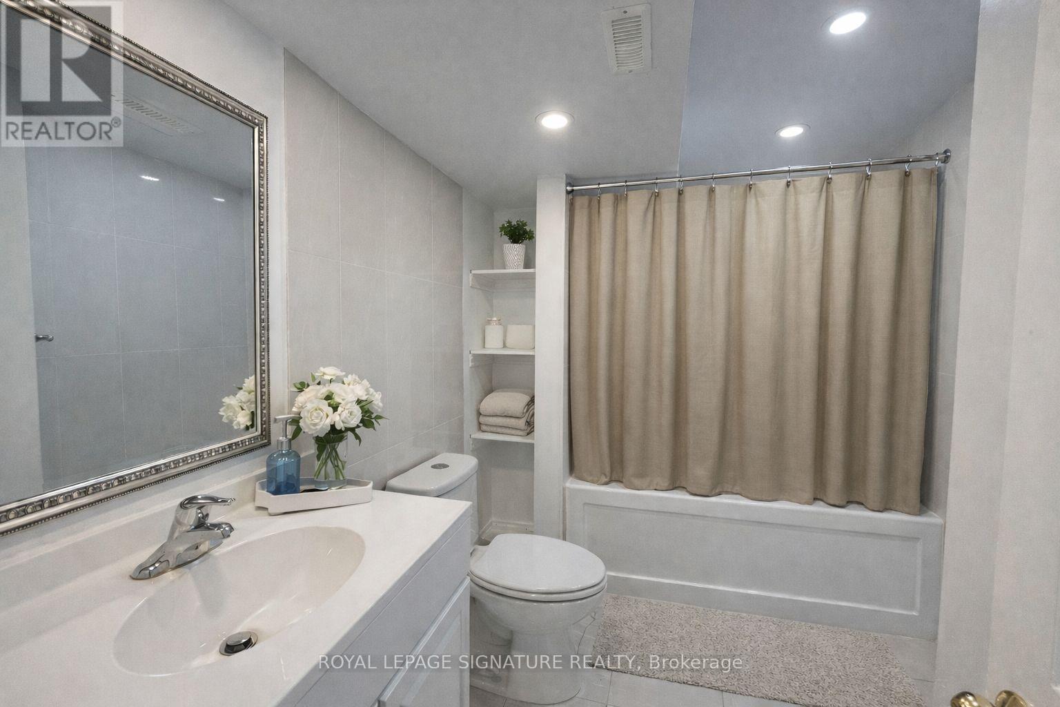 A white bathroom with a sink, toilet, and shower.
