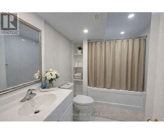 A white bathroom with a sink, toilet, and shower.